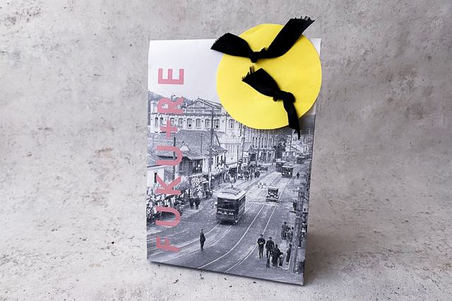 ハロウィンのラッピングアイディア、黄色い画用紙と黒いリボンで作った月とコウモリ